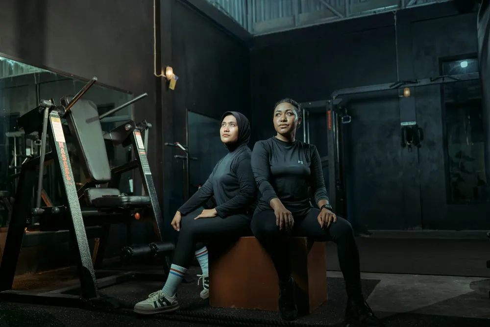 Two women resting in a gym