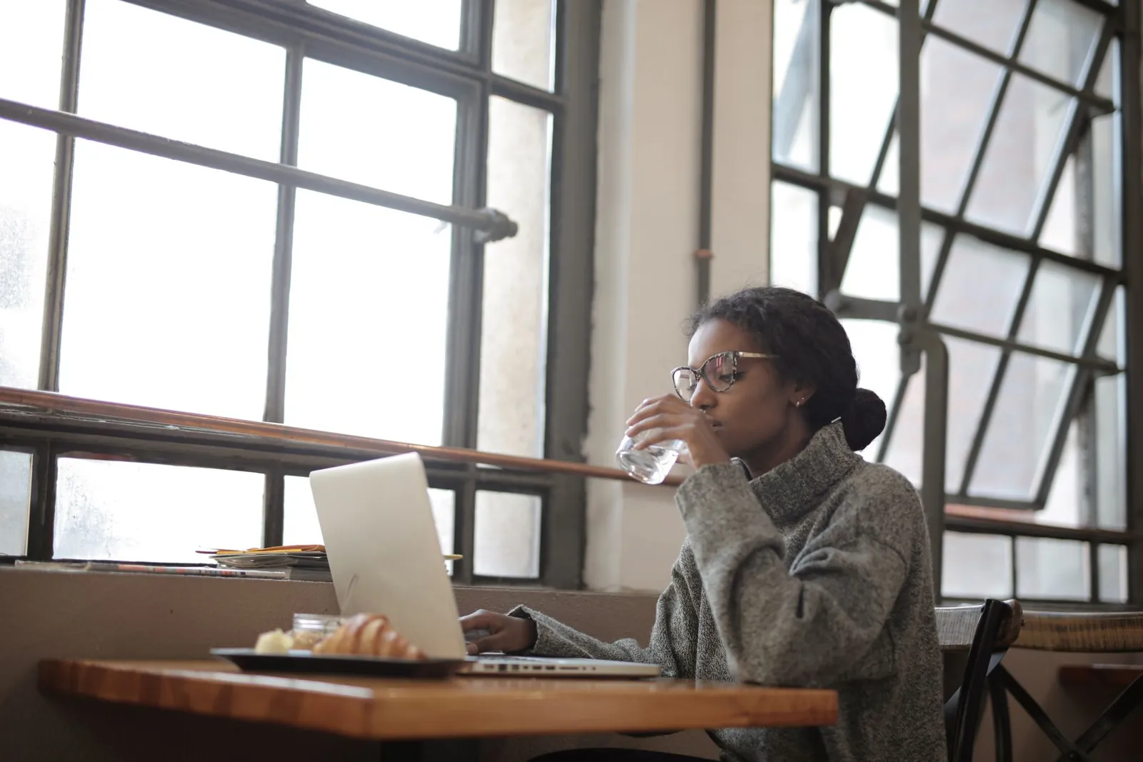 A woman at an office window with a glass of water