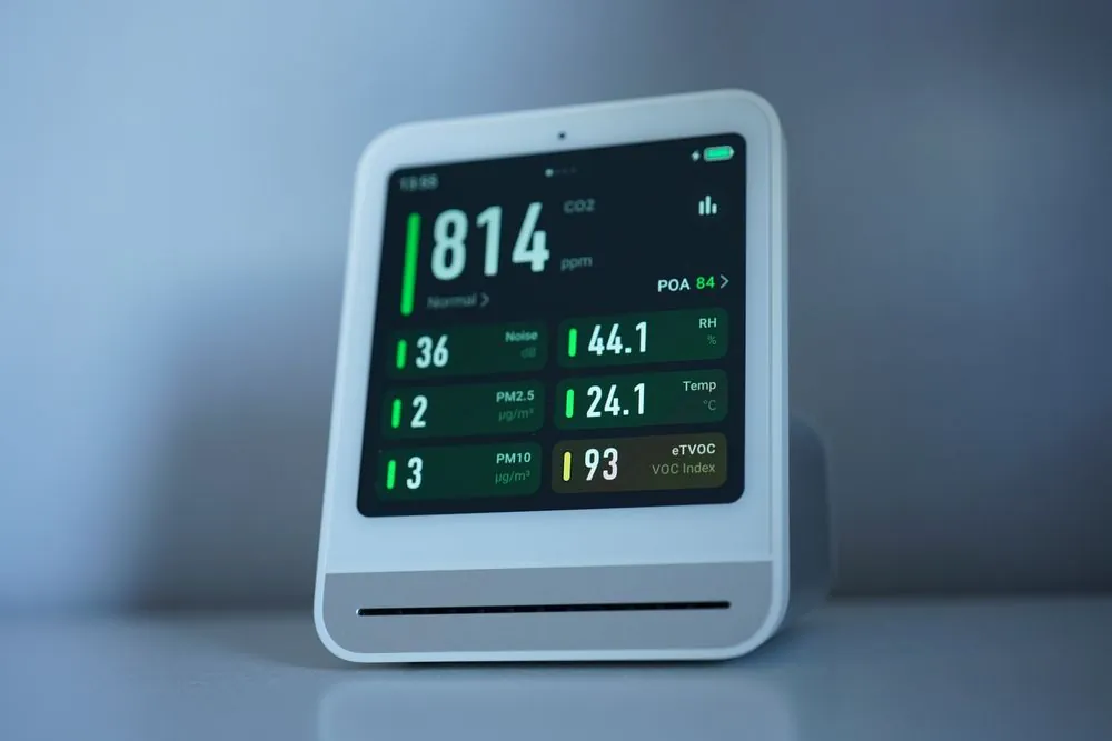Indoor air quality monitor showing CO2 and particle readings